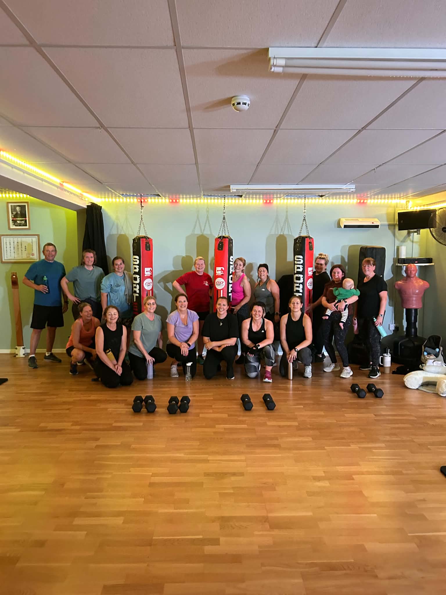 Group fitness class posing together in a boxing studio