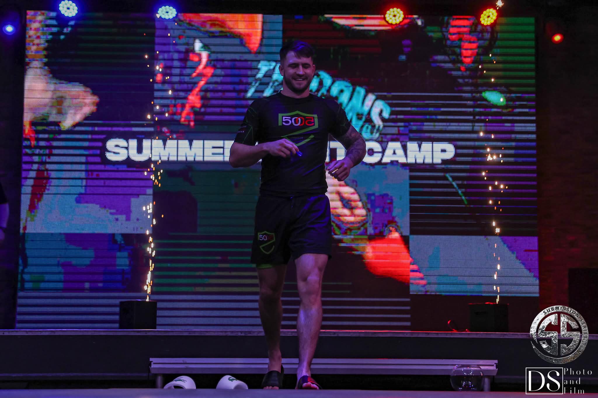 Athlete entering a combat sports event under stage lights