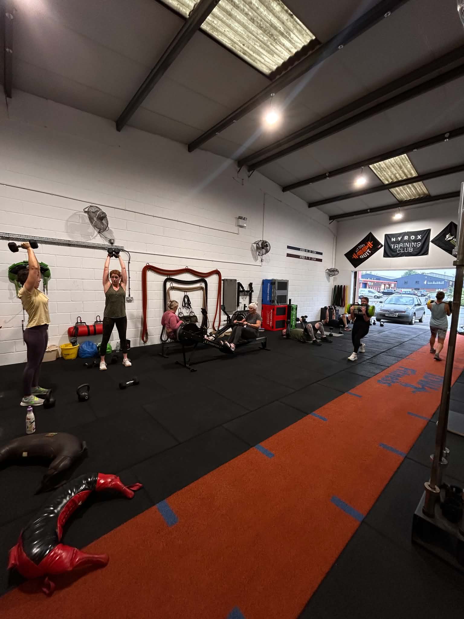Group conditioning session with dumbbells and rowing machines